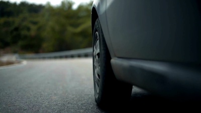 汽车左前轮特写视频在一条扭曲的道路上。