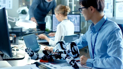 电子工程师与Robot一起工作，操纵其反应笔记本电脑，高级工程师与首席程序员交谈。计算机科学研究实验室与专家一起工作。