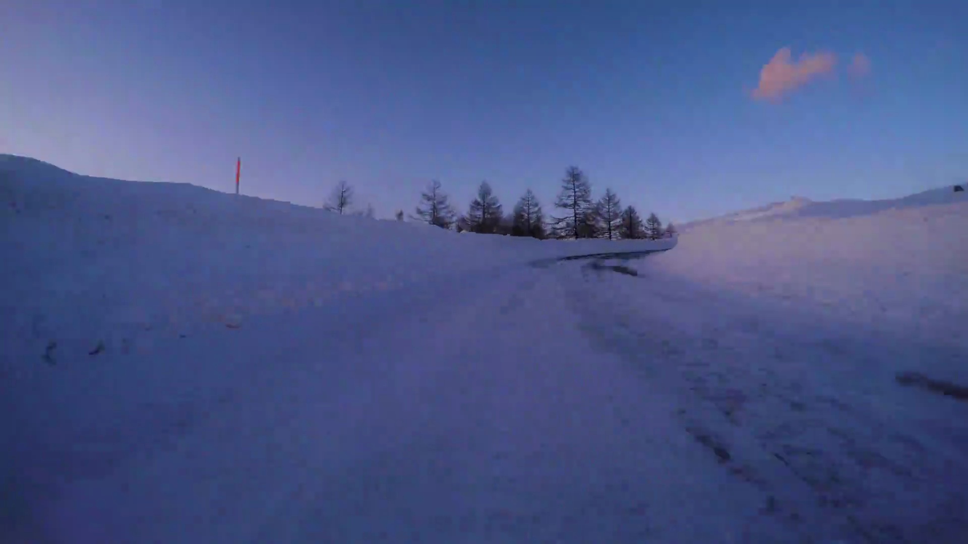 黄昏时驾车行驶在冰雪覆盖的冬季公路上- -