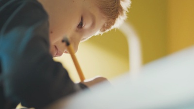 男孩(10-11)在办公桌前做作业的特写镜头
