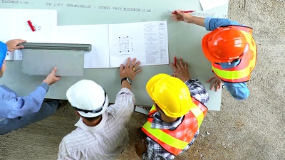 建筑师和工程师会议计划一个新项目的施工设备在桌子上。