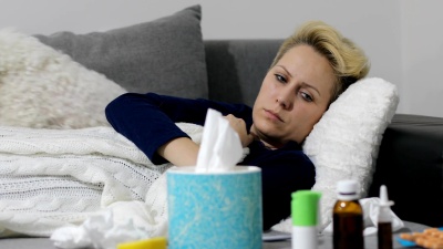 生病的女人感冒了女人感冒了打喷嚏到组织中。头疼病毒