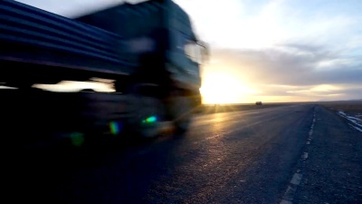 在金色云天的乡村道路上行驶的卡车