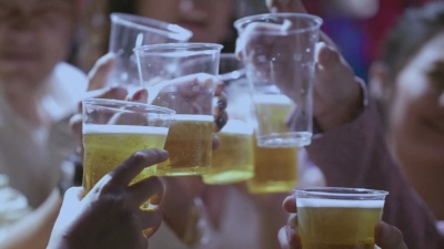 真实的人们用啤酒杯欢呼和祝酒