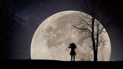 女孩看夜星以超级月亮为背景的时光流逝