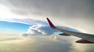 日落时分飞机飞过奇妙的云层和天空的 镜头
