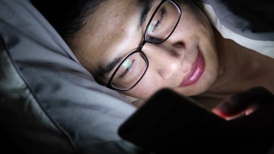 特写年轻人在床上使用手机