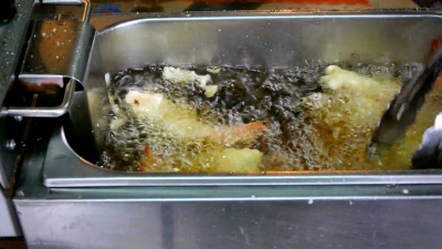  镜头，厨师手工烹饪油炸对虾，天妇罗日式食物，在厨房