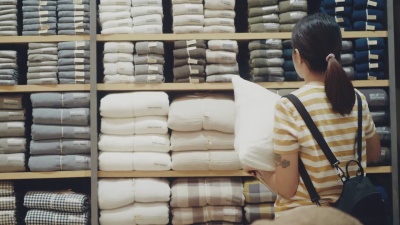 年轻的亚洲女人在商店里买布
