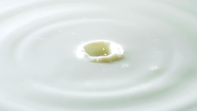 白色牛奶液体表面的水滴和波纹