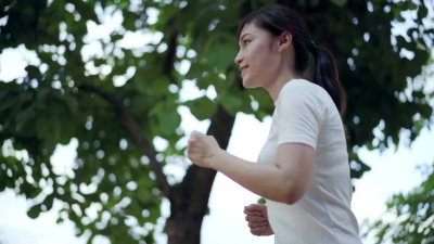 年轻女子在公园跑步的慢动作