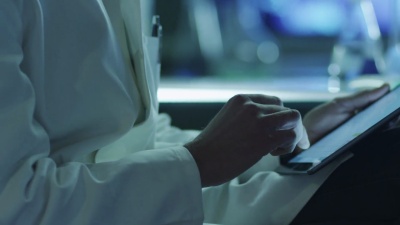 中年男性科学家在实验室使用片剂