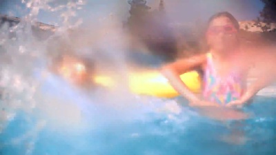 男孩女孩在游泳池里泼水玩得很开心