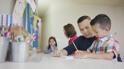父亲帮助他的小男孩做功课