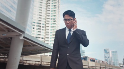 城市中的商人散步和电话交谈