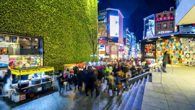 明洞市场的时光流逝。韩国首尔，人们晚上走在购物街上