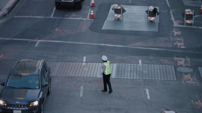 在洛杉矶市中心的十字路口指挥车辆的警官交通警察。LADOT交通主任指挥交通