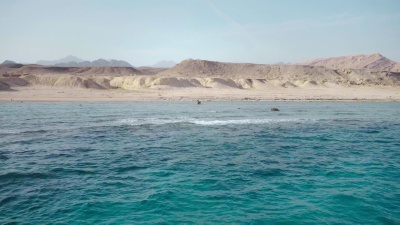 晶莹剔透的红海深水和荒岛的海岸。全景
