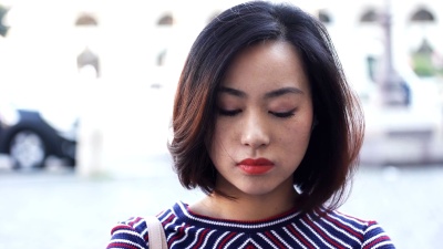 城市里的年轻亚洲女人白天，微笑快乐的脸庞肖像