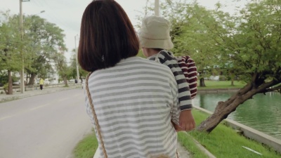 年轻的母亲带着儿子走在人行道上