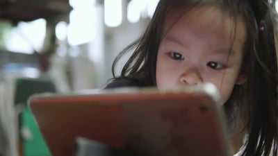 亚洲小女孩使用数字平板电脑。