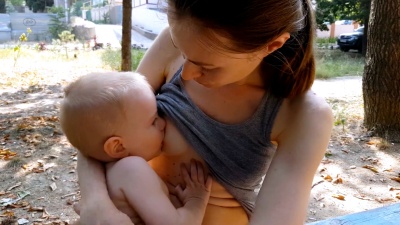 妈妈在户外安慰和哺乳哭闹的婴儿