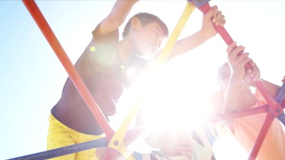 小学生在操场上的圆顶登山者上玩耍