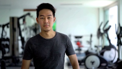 亚洲男子双臂交叉，在健身房微笑