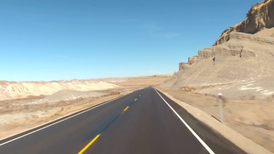 FPV 在美国犹他州，沿着空旷的道路行驶，穿过灰色的沙地沙漠峡谷