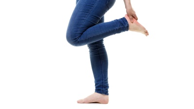 女性腿部疼痛，白色背景下女性脚部按摩