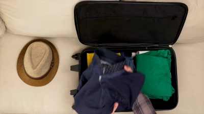 一名男子正在完成将衣服包装到旅行袋中