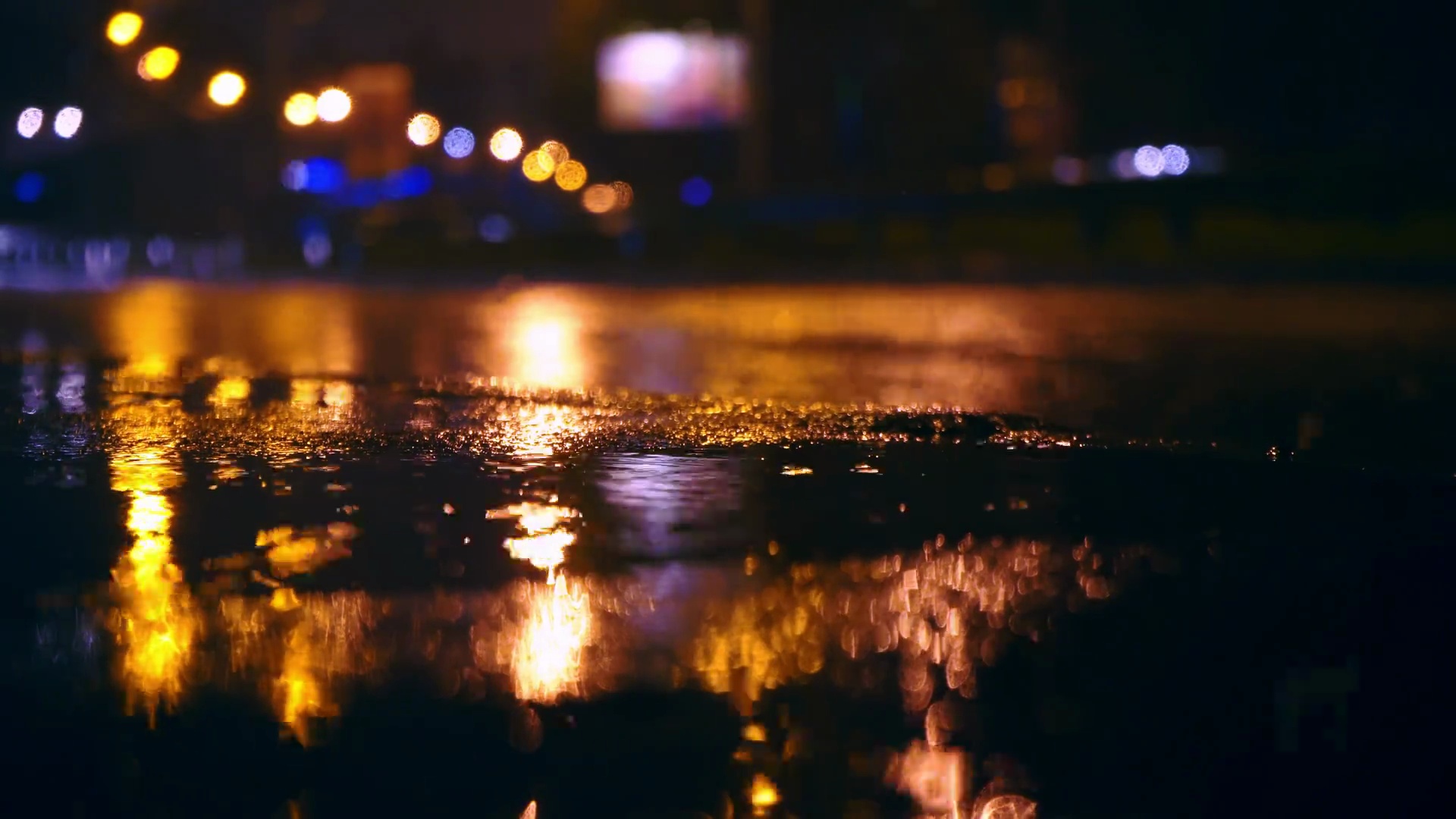 汽车在城市的夜间道路上驶入大水坑，喷雾水坑从汽车车轮下散开。