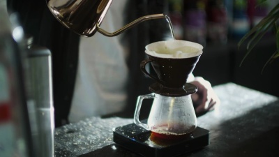 日本咖啡师在磨碎的咖啡上倒热水
