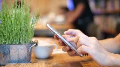 女人用手发短信，在咖啡馆用智能手机