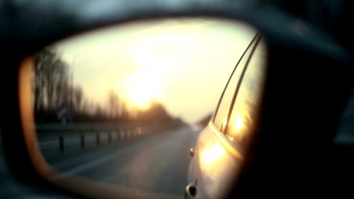 日落时后视镜中的道路视图