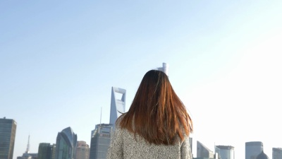 年轻的亚洲女性站在现代城市