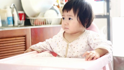   母亲在1岁女婴的鼻子上喷药，滴鼻剂喷雾。