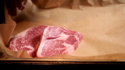 厨师在木板上切肉。餐厅提供新鲜生肉。选择性聚焦。