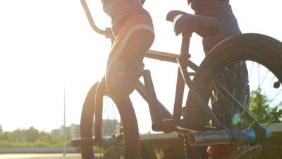 慢动作特写 BMX摩托车手在大街上蹬和跳360度旋转技巧