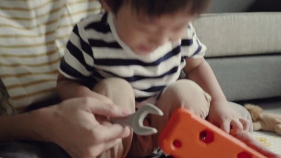 年轻的母子在家里客厅的地板上玩耍。