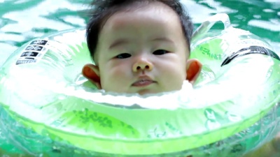 男婴在儿童充气游泳池游泳