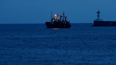 拖网渔船退出海湾进行夜间捕鱼