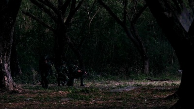 剪影，全副武装的士兵小队在森林中单列行走