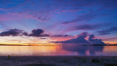 热带海滩和海洋上的延时日出。五颜六色戏剧性的黄昏天空。浪漫的激情概念。印度尼西亚，苏门答腊岛，巴尼亚克群岛。