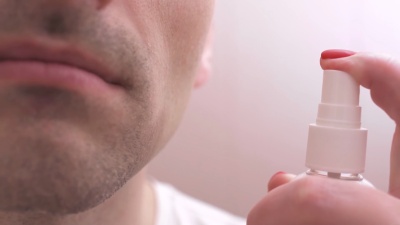 一个男人在用保湿霜刮脸后照顾他的脸部皮肤