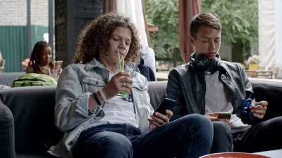 青少年在户外咖啡馆使用电子产品