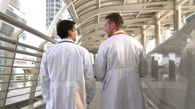 医生和患者在户外观看报告文件并进行讨论
