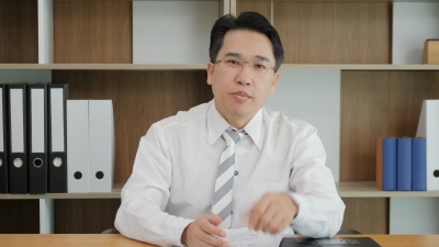 有吸引力的亚洲男子录制视频信息在网络摄像机上交谈，顾问通过视频电话向客户提供报价，视频记录员记录视频日志，培训有效的业务介绍。