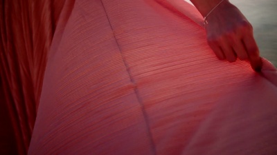 海滩上穿着被风吹过的衣服的女人
