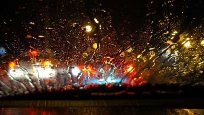   夜间城市交通堵塞时，雨滴落在汽车后视镜上